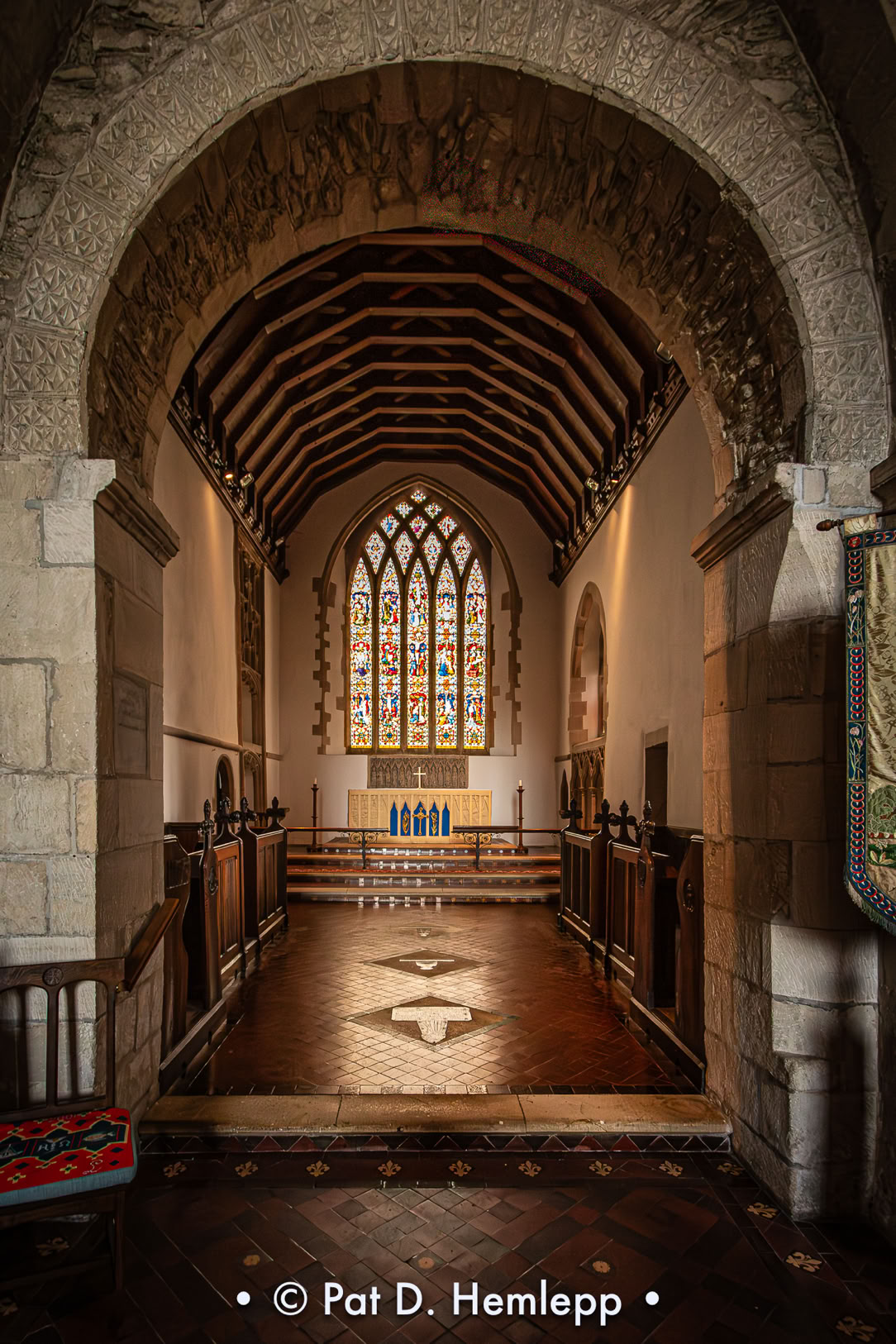 The chapel inside The Church of Saint Mary the Virgin in Bampton, Oxfordshire, England, is illuminated by light filtering through a stained glass window.