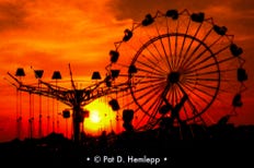 The sun sets behind carnival rides in a Kmart parking lot in Russell, Ky., June 1977.