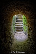Daylight illuminates steps at the end of a tunnel carved through rock, Hocking Hills State Park, Logan, Ohio.