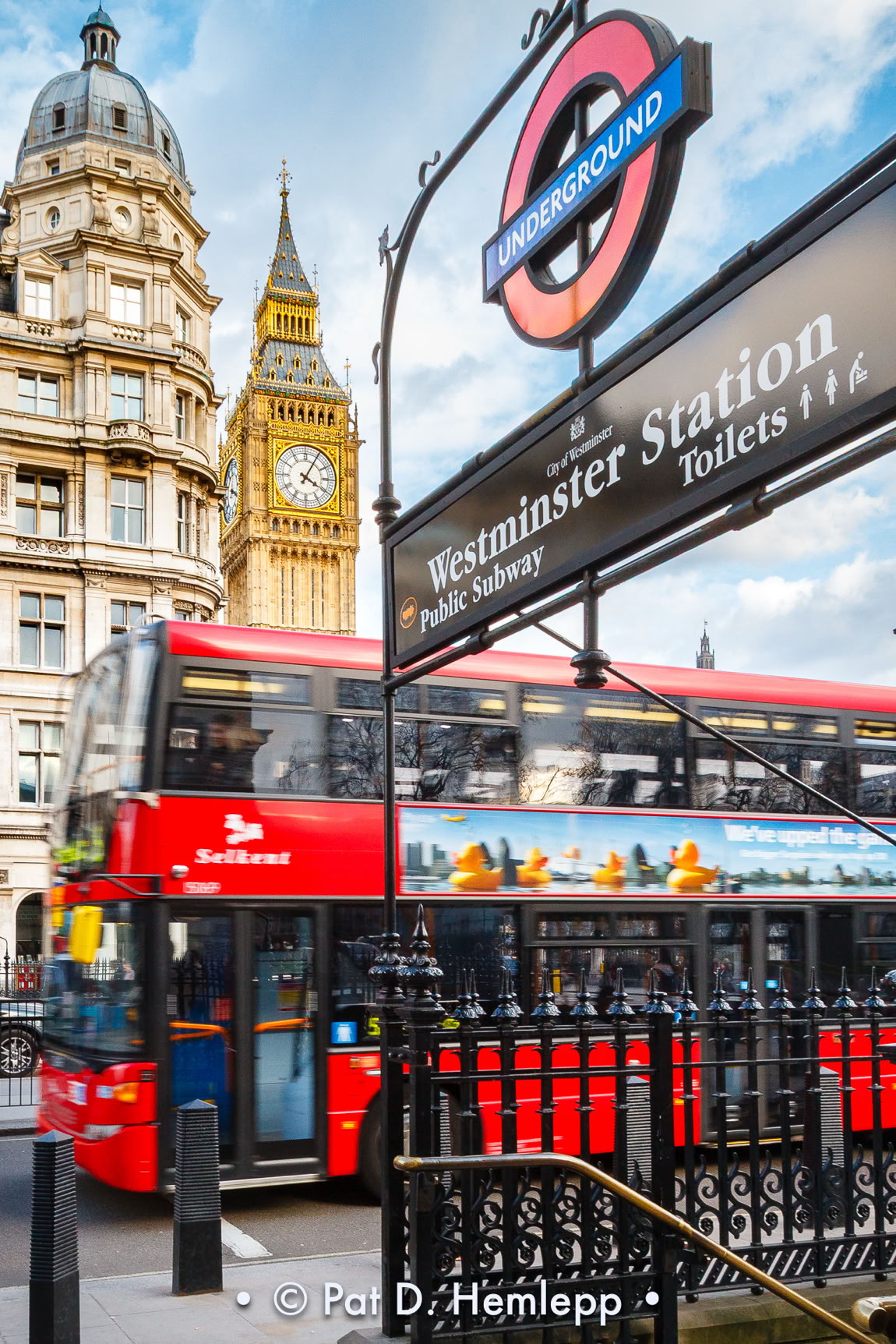 Big Ben stands above a passing bus and the Westminster Station of the London Underground, London, England.